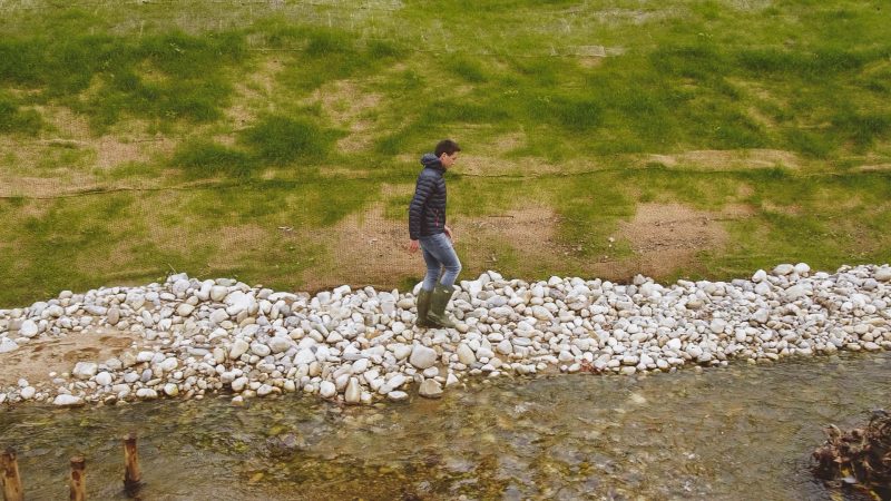 Guillaume Lachana marche sur des galets au bord de l'Yzeron à Sainte-Foy-lès-Lyon