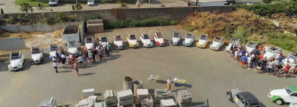 Des employés de Green Style écoutent les consignes pour conduire une 2CV