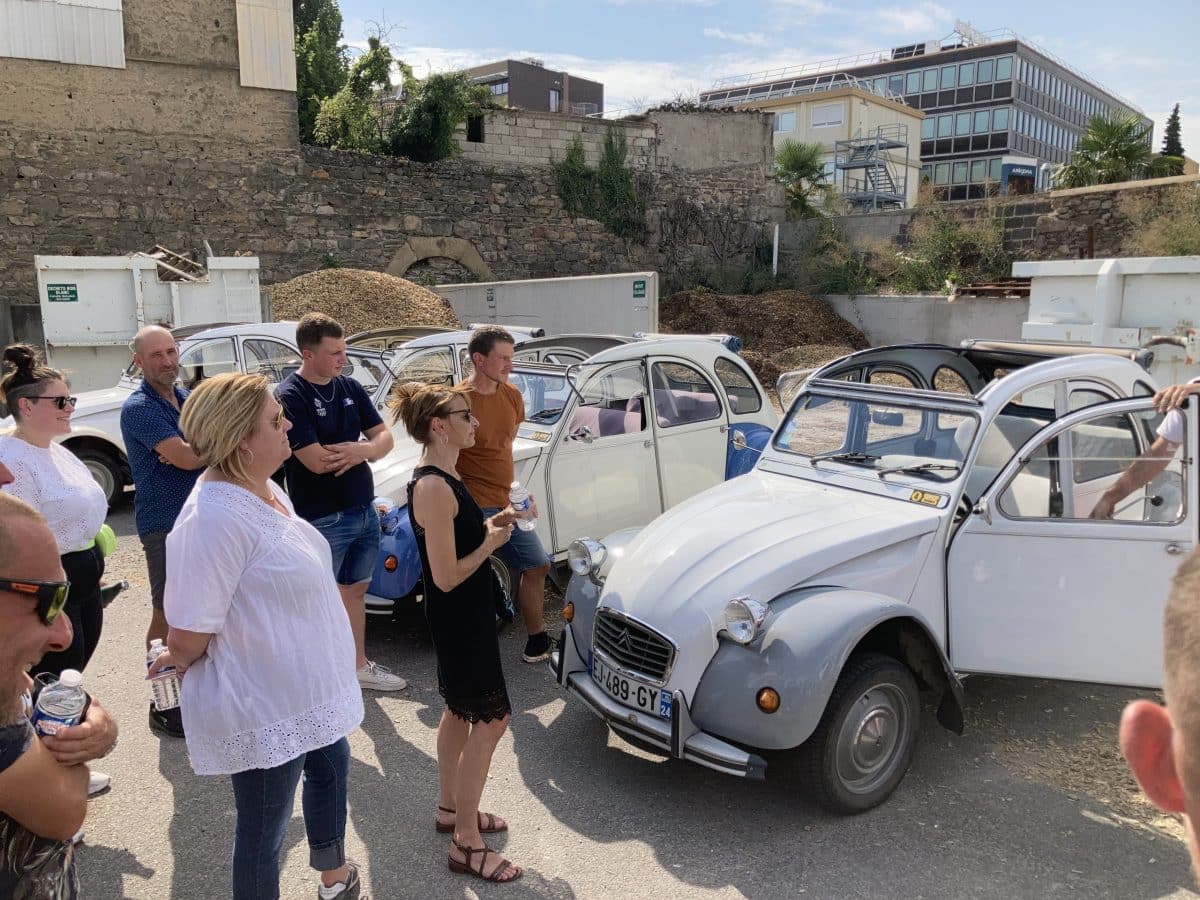 Des employés de Green Style écoutent les consignes pour conduire une 2CV